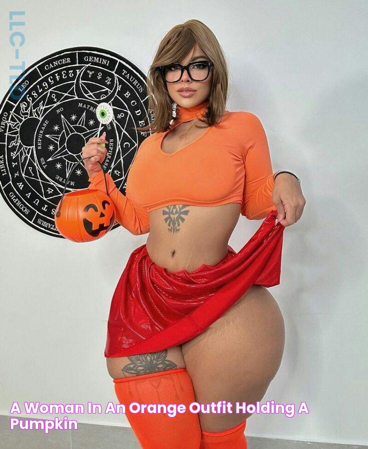 a woman in an orange outfit holding a pumpkin