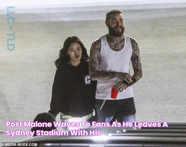 Post Malone waves to fans as he leaves a Sydney stadium with his