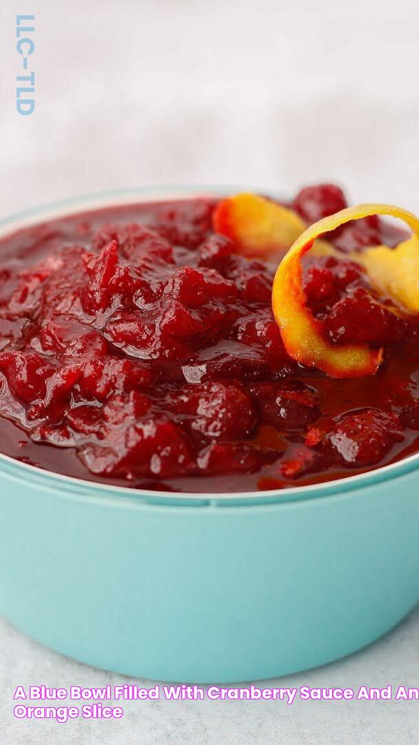 a blue bowl filled with cranberry sauce and an orange slice