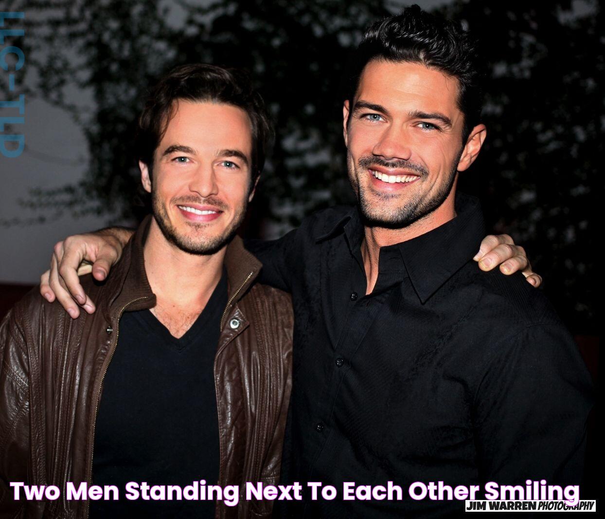 two men standing next to each other smiling